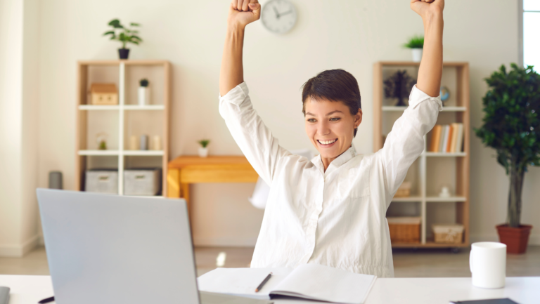 lawyer with hands raised in excitement with laptop