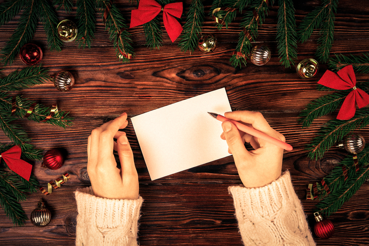 photo of woman's hands getting ready to write a holiday card
