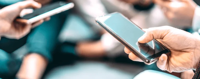 Group of people holding mobile devices in their hands