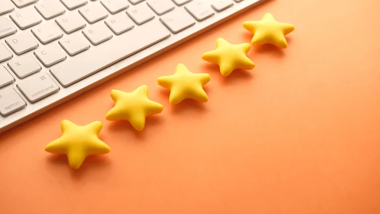 keyboard with 5 stars next to it on an orange desk