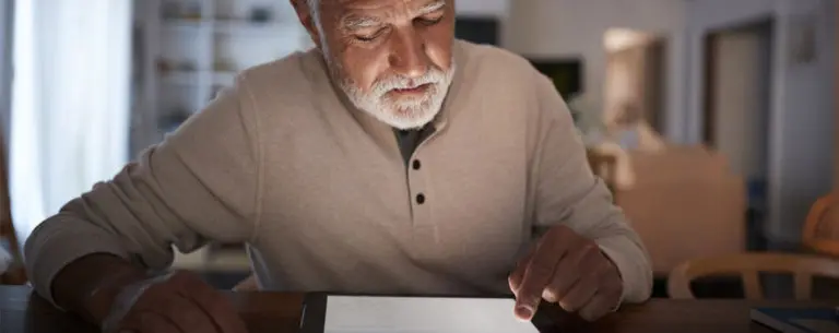 senior man looking at his tablet