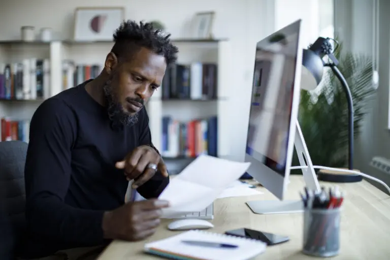 Male attorney reviews paperwork (detailing rising costs during recession)