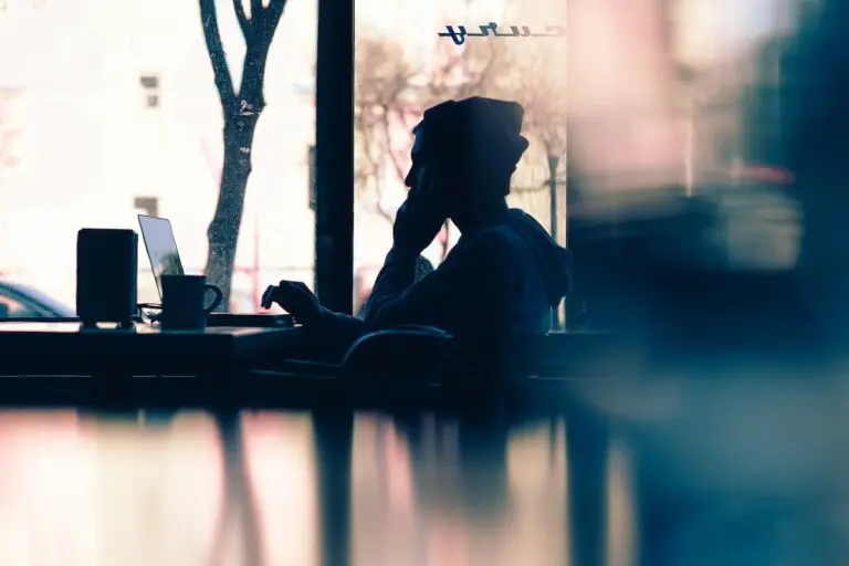 silhouette of woman working on her laptop in shop